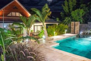 une villa avec une piscine la nuit dans l'établissement Villa Akiba piscine chauffée & jacuzzi d'exception, à Saint-Pierre