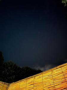 una vista nocturna de una valla con un cielo oscuro en Fuji-Hakone Guest House en Hakone