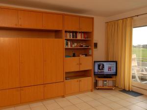 een woonkamer met houten kasten en een televisie bij Haus-Hooge-Whg-04 in Sankt Peter-Ording