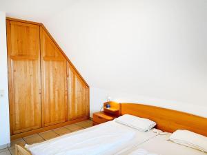 een slaapkamer met 2 bedden en een houten hoofdeinde bij Haus-Hooge-Whg-04 in Sankt Peter-Ording
