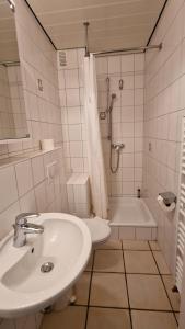 een badkamer met een wastafel, een douche en een bad bij Haus-Hooge-Whg-04 in Sankt Peter-Ording