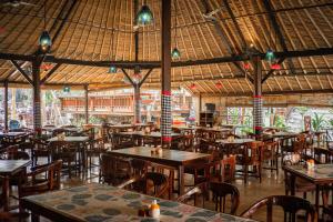 um restaurante vazio com mesas, cadeiras e luzes em Puri Saraswati Dijiwa Ubud em Ubud