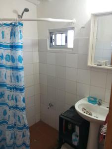 y baño con cortina de ducha y lavamanos. en El Navegante, en Cabo Polonio