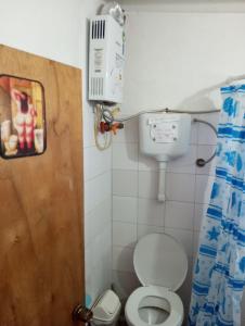 a small bathroom with a toilet and a air conditioner at El Navegante in Cabo Polonio