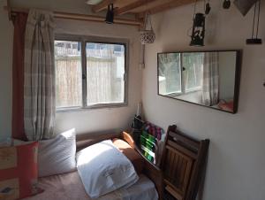 1 dormitorio con cama y espejo en la pared en El Navegante, en Cabo Polonio