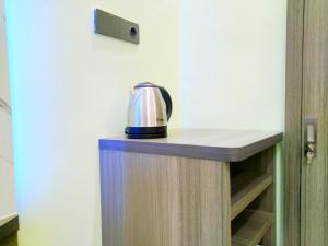 a coffee pot sitting on top of a wooden shelf at Shiva Home Syariah RedPartner near Alun Alun Tegal in Tegal