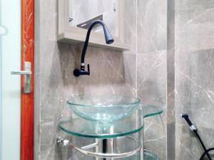 a glass sink in a bathroom with a faucet at Shiva Home Syariah RedPartner near Alun Alun Tegal in Tegal