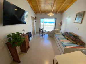 ラス・グルータスにあるDepto Frente a la playa, con vista al marのソファと薄型テレビのあるリビングルーム