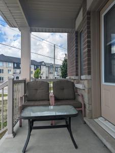 eine Terrasse mit einem Sofa und einem Tisch auf einer Veranda in der Unterkunft Honey Dew in Bowmanville