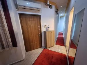einen Flur mit einer Holztür und einem roten Teppich in der Unterkunft Amazing TaKSIM Apartment 2 in Istanbul