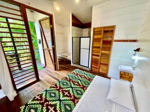 Habitación pequeña con cama y espejo. en Rema K A Y A K Lodge, en Tena