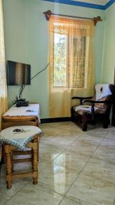 sala de estar con 2 camas y ventana en Galapagos Homestay, en Lushoto