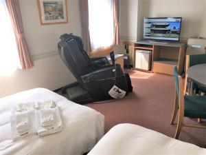 um quarto de hotel com duas camas e uma televisão em Hotel Alpha-One Takaoka em Takaoka