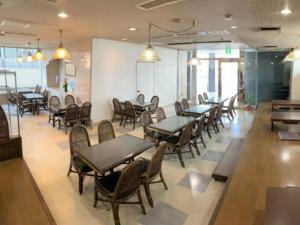 a dining room with tables and chairs in a restaurant at Hotel Alpha-One Takaoka in Takaoka