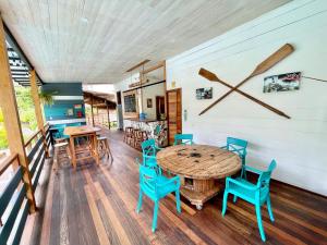 a dining room with a wooden table and blue chairs at Rema K A Y A K Lodge in Tena