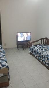 ein Wohnzimmer mit 2 Betten und einem Flachbild-TV in der Unterkunft Apartamento na rua do Santuário in Aparecida