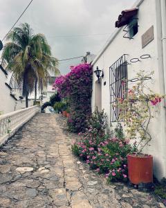 a cobblestone street next to a building with flowers at cabaña la bonita habitacion 302 in Doradal