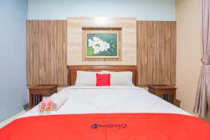 um quarto com uma cama grande e um cobertor vermelho em RedDoorz Resort Premium @ Sangkan Hurip Kuningan em Kuningan