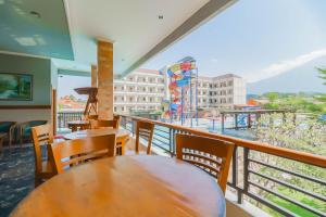 um restaurante com mesas e cadeiras e vista para um parque infantil em RedDoorz Resort Premium @ Sangkan Hurip Kuningan em Kuningan