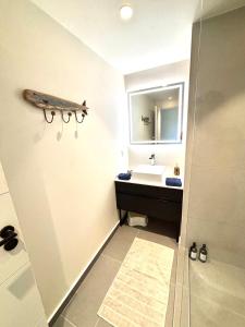 a bathroom with a sink and a mirror at Pacific cosy home Bougainvilliers in Punaauia