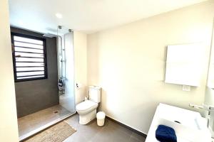 a bathroom with a toilet and a shower and a sink at Pacific cosy home Bougainvilliers in Punaauia