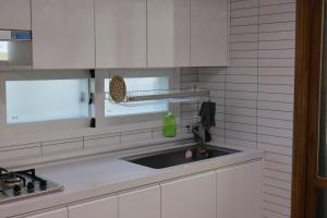uma cozinha com armários brancos e um lavatório em Clover Stay, 2BR,1BA,mapo, free-wifi, em Seul