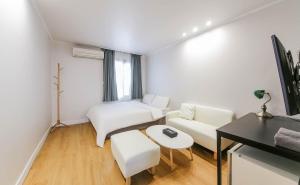 a white living room with a couch and a table at Lofy house in Jeju