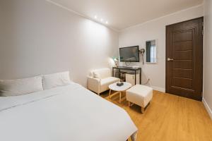 Dormitorio con cama, escritorio y TV en Lofy house, en Jeju