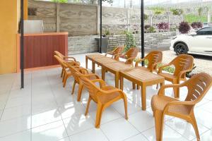 eine Reihe von Holztischen und -stühlen in einem Restaurant in der Unterkunft Urbanview Hotel Nerine's Glamping Village Cipanas by RedDoorz in Barukupa