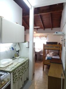 a kitchen with white cabinets and a table in a room at LUZ MAR San Clemente del Tuyú in San Clemente del Tuyú