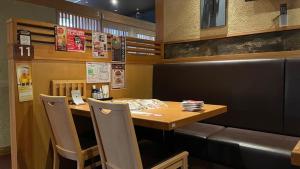 a restaurant with a table and chairs in a room at Hotel Alpha-One Sabae in Sabae