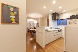 a kitchen with a white refrigerator and a table at Eldor Nishikojiya - Vacation STAY 12256 in Tokyo