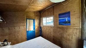 Habitación pequeña con cama y ventana en Cabo Polonio - Rancho 66, en Cabo Polonio