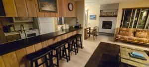 a kitchen with a bar with chairs and a living room at Standard Condos with Free Parking in Mammoth Lakes