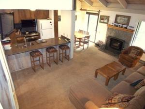 a living room with a couch and a kitchen with a fireplace at Standard Condos with Free Parking in Mammoth Lakes