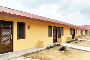 a yellow house with a red roof at Urbanview Hotel Nerine's Glamping Village Cipanas by RedDoorz in Barukupa