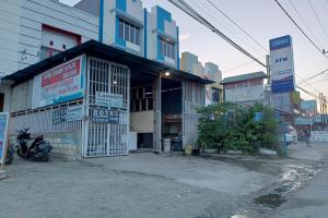 un edificio con una moto parcheggiata di fronte di OYO 93485 Hotel Kenzie Sentani a Jayapura