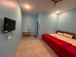 1 dormitorio con 1 cama y TV de pantalla plana en Selvas Eden Resort with river view near boat house, en Pondicherry