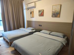 Habitación de hotel con 2 camas y ventana en Showbiz Hostel en Yangshuo