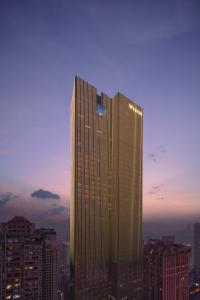 a tall skyscraper in a city at sunset at The Westin Chongqing Liberation Square in Chongqing