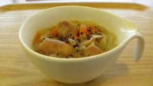 a white bowl of soup on a wooden table at Hotel Alpha-One Tsuruga Bypass in Tsuruga