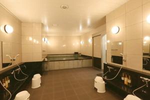 a large bathroom with two toilets and a sink at Hotel Alpha-One Tsuruga Bypass in Tsuruga