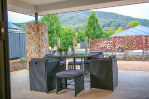 a patio with a table and chairs and a fireplace at Amaroo in Bright