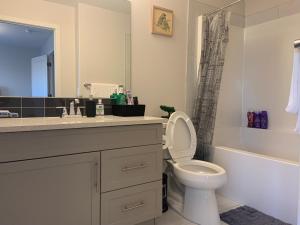 Un baño con inodoro, lavabo y bañera. en Glamorous 3 BR Villa with Double Garage, en Regina 41 fotos más
