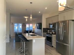 una cocina con refrigerador de acero inoxidable y encimera en Glamorous 3 BR Villa with Double Garage, en Regina