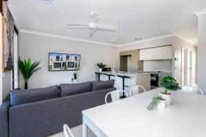 a living room with a couch and a kitchen at Cheerful 3 Bedroom townhouse with Parking in Gold Coast