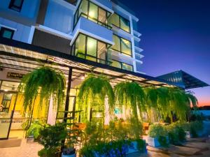 a building with palm trees in front of it at บ้านสุขใจ สามใบเถา 