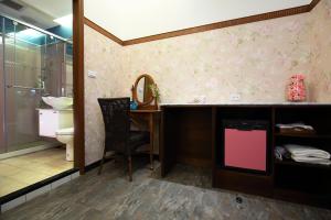 baño con aseo y escritorio con espejo en Rose Garden, en Hualien City