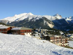 einen schneebedeckten Hügel mit Gebäuden und Bergen im Hintergrund in der Unterkunft Appartement Aussois, 2 pièces, 4 personnes - FR-1-508-289 in Aussois