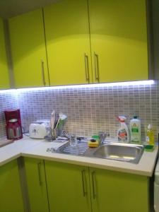 eine Küche mit grünen Schränken und einem Waschbecken in der Unterkunft DUO Apartmanok in Sárvár